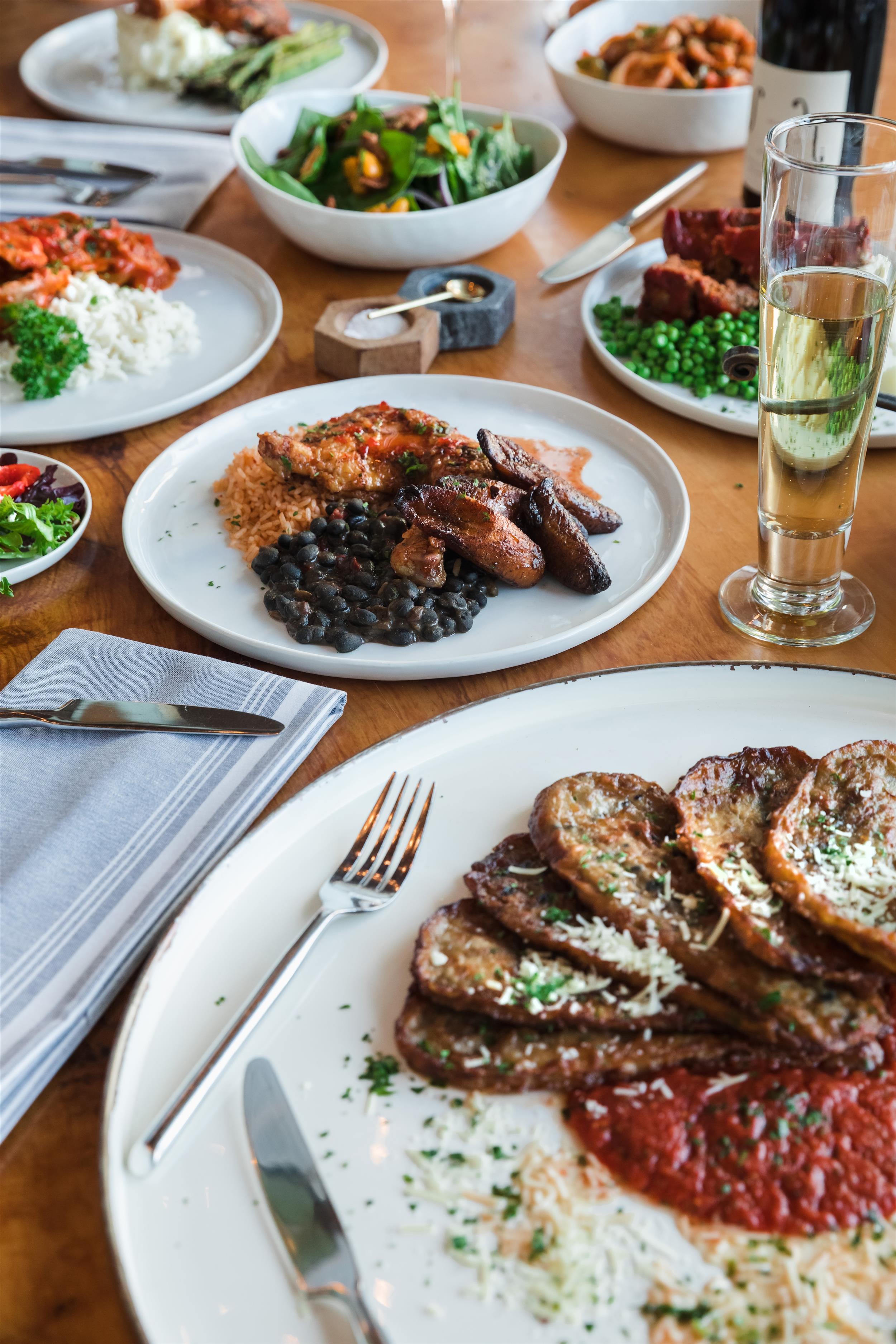 a table with several plates of food and glasses of drink