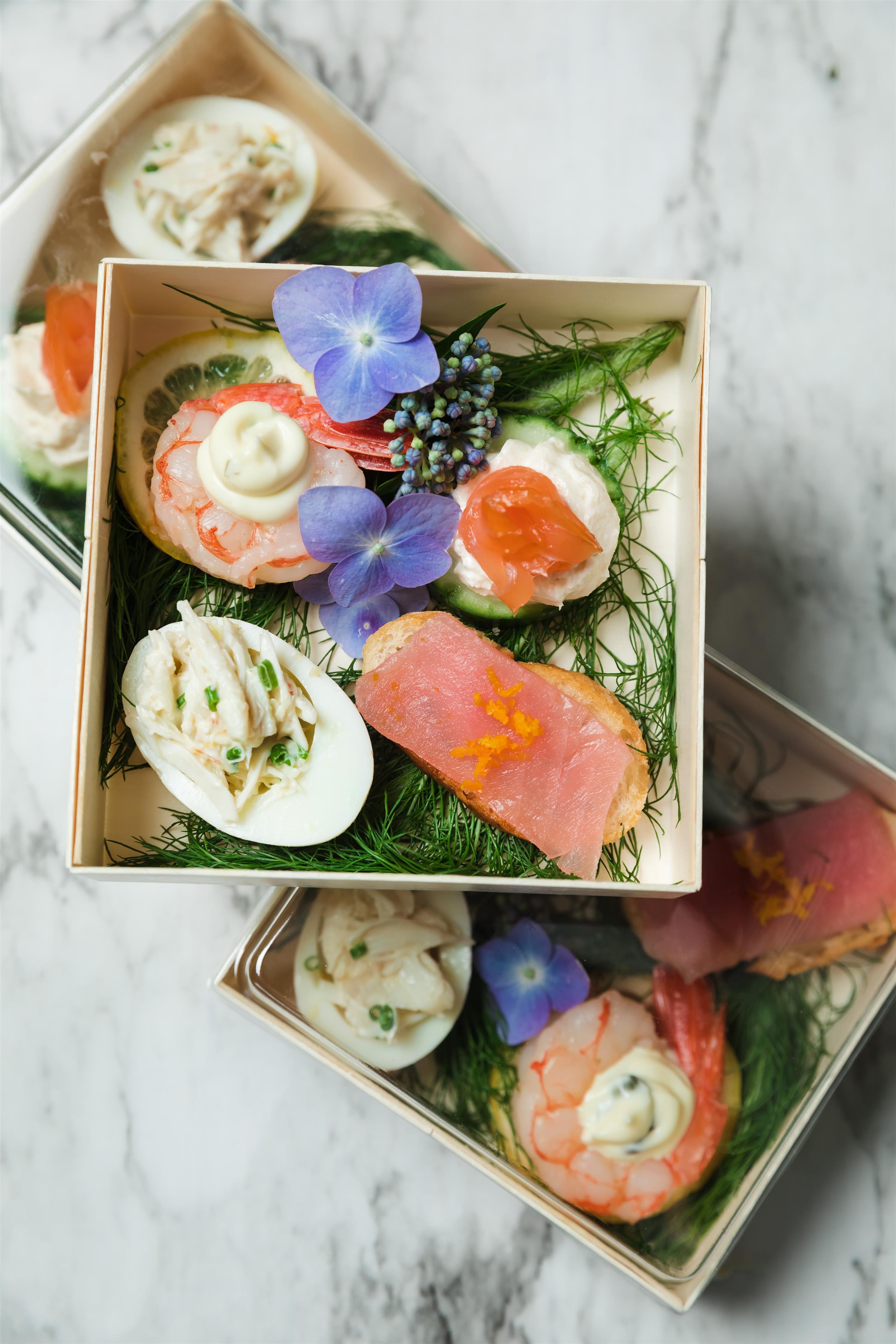a box of food with shrimp, egg, and toast